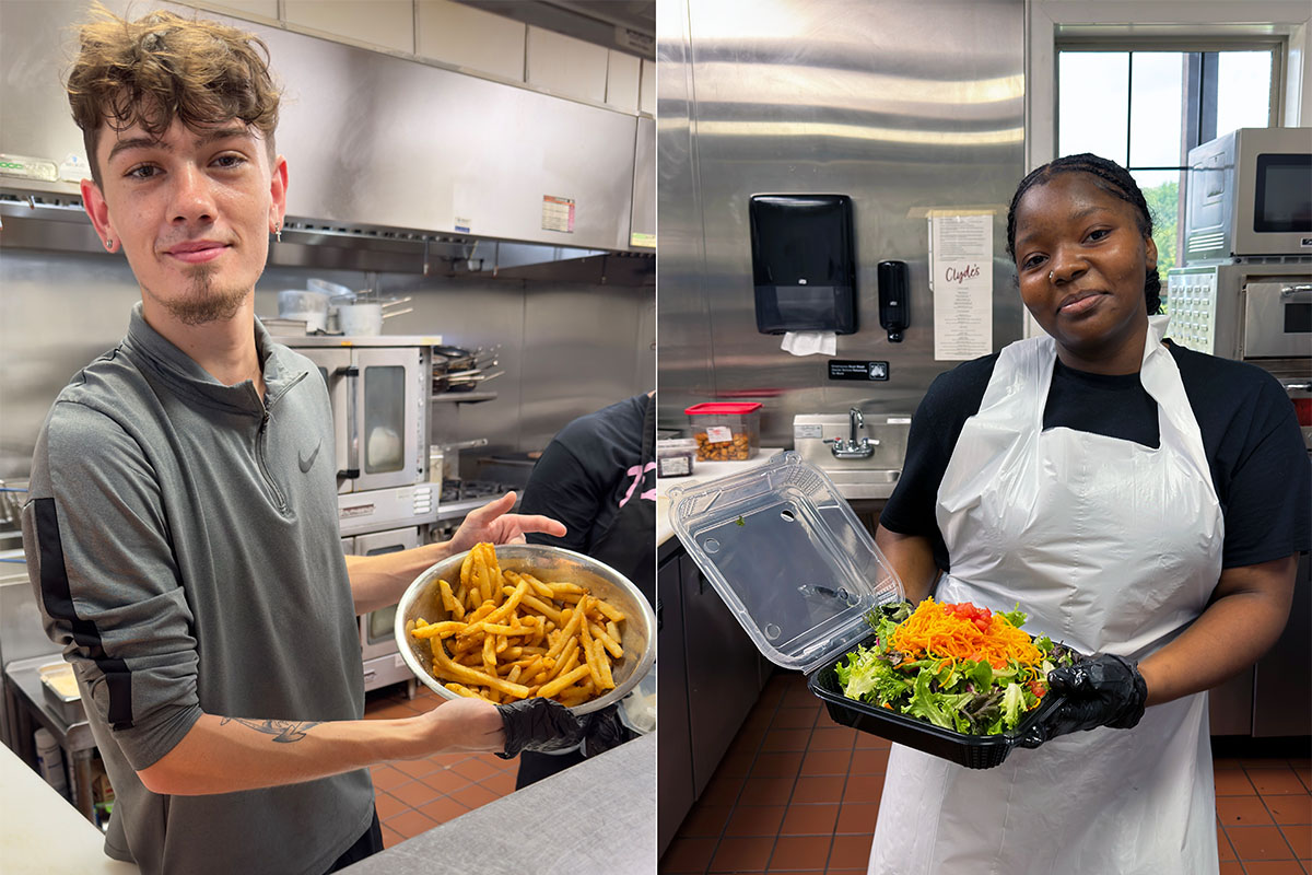 Caleb Crutcher preparing a fries order and Kamaya Woodson constructing a salad
