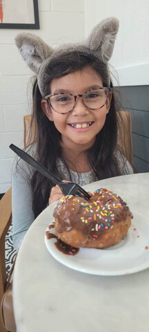 Crystal Blough enjoying a chocolate doughnut at Parlor Doughnuts