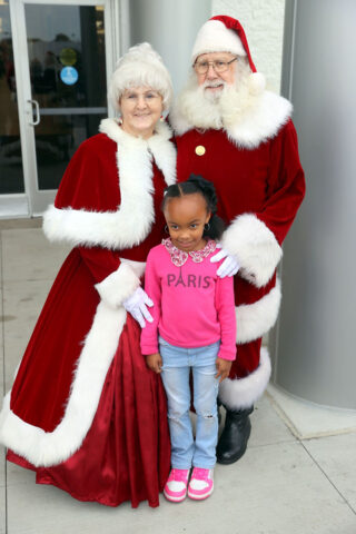 Mrs. Claus and Santa Claus with a little girl outside the mall. (Mark Haynes, Clarksville Living Magazine)