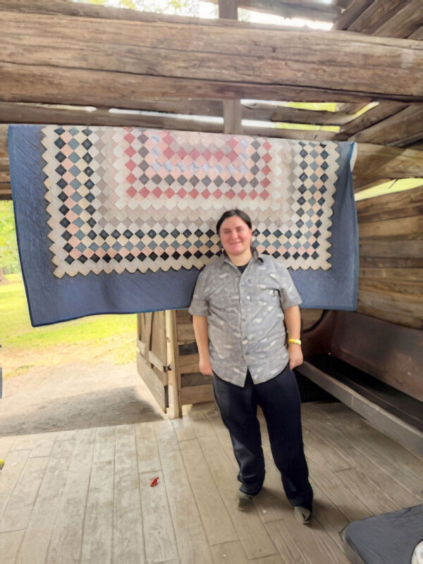 David Bidleman, historical educator, with an antique quilt from Homeplace 1850’s Working Farm and Museum David Bidleman, historical educator, with an antique quilt from Homeplace 1850’s Working Farm and Museum