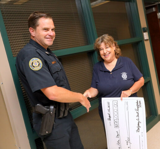 CPD Chief Ty Burdine receives a check from Montgomery County First Responders Association's Lori Mason